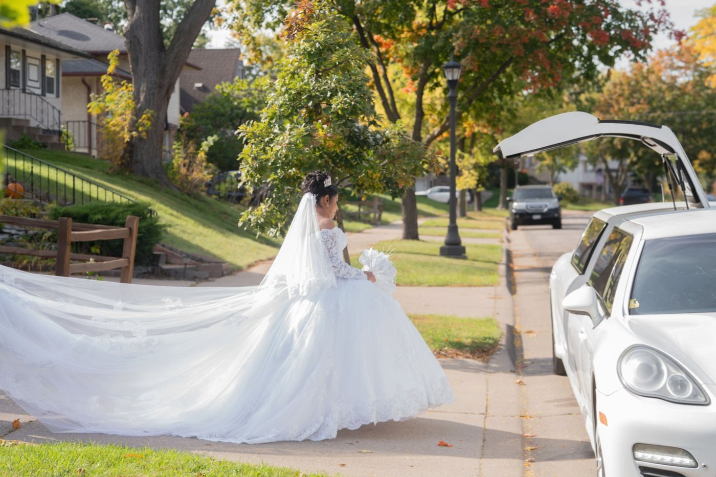 La novia caminando hacia el coche con la cola del vestido extendida