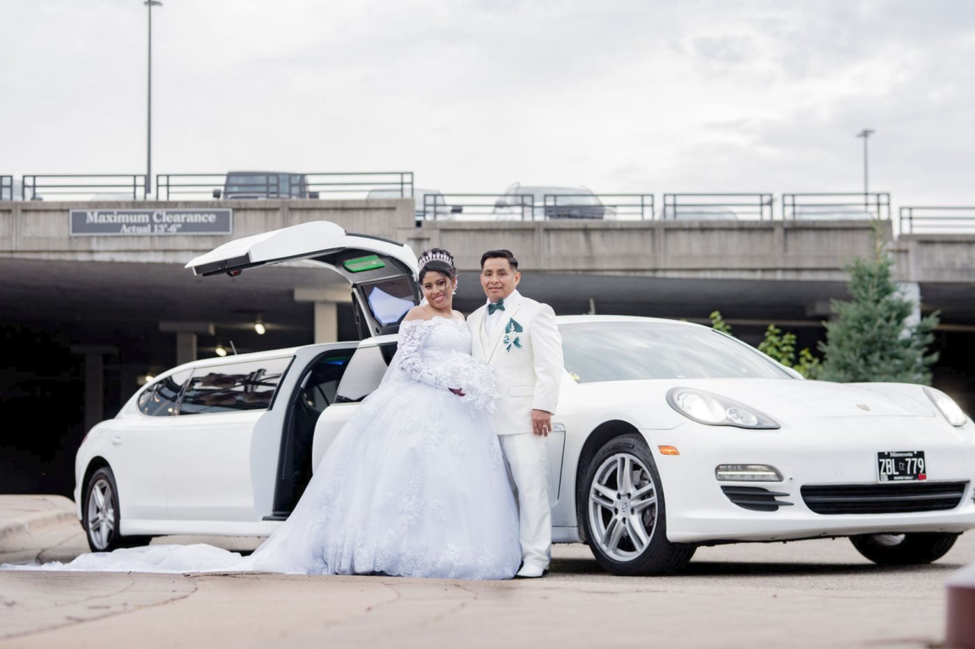 Los novios junto al coche blanco de la boda