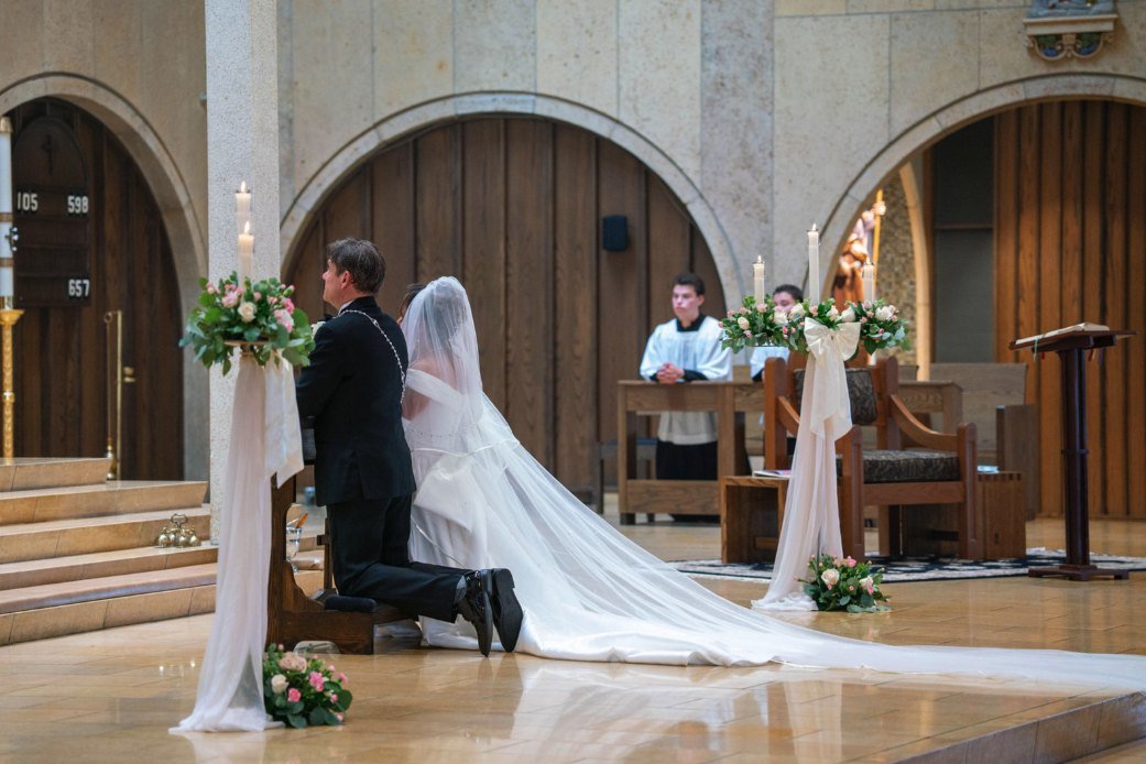 Los novios arrodillados ante el altar durante la ceremonia