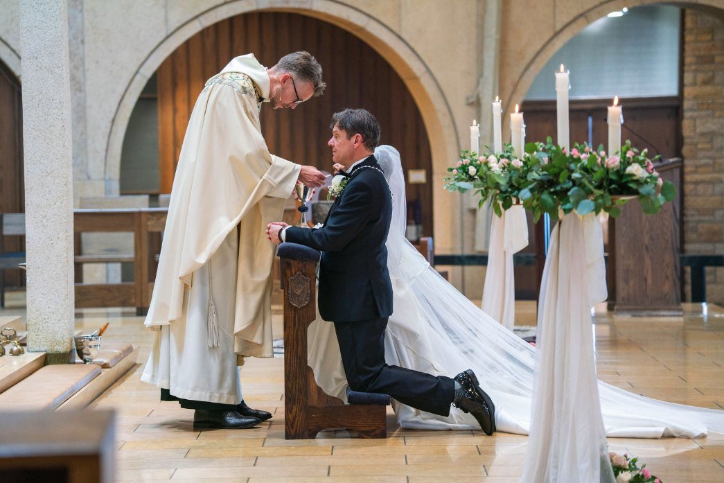 El novio recibiendo la comunión de manos del sacerdote