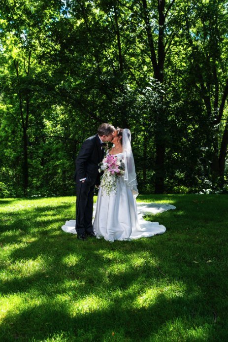 Los novios besándose en un claro del bosque