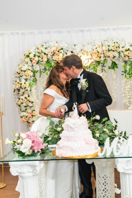 Los novios besándose mientras cortan el pastel
