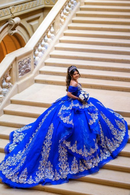 Quinceañera mirando por encima del hombro en la escalinata, con la cola extendida